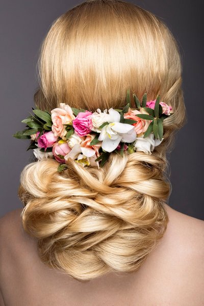 Elegante Flechtfrisur mit Blumen im Haar
